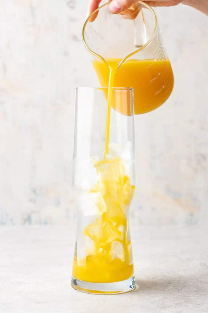Pour the orange mango juice into a glass filled with ice