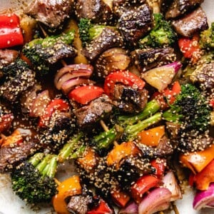 Grilled beef and vegetable kabobs on a big white plate