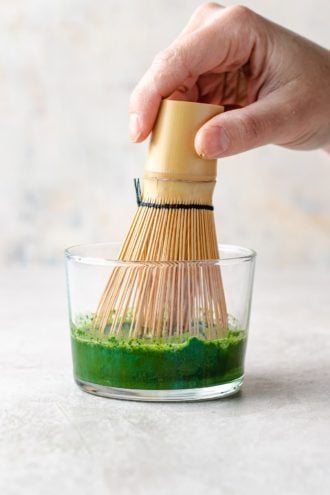 picture shows whisking the matcha tea powder with water with matcha whisk