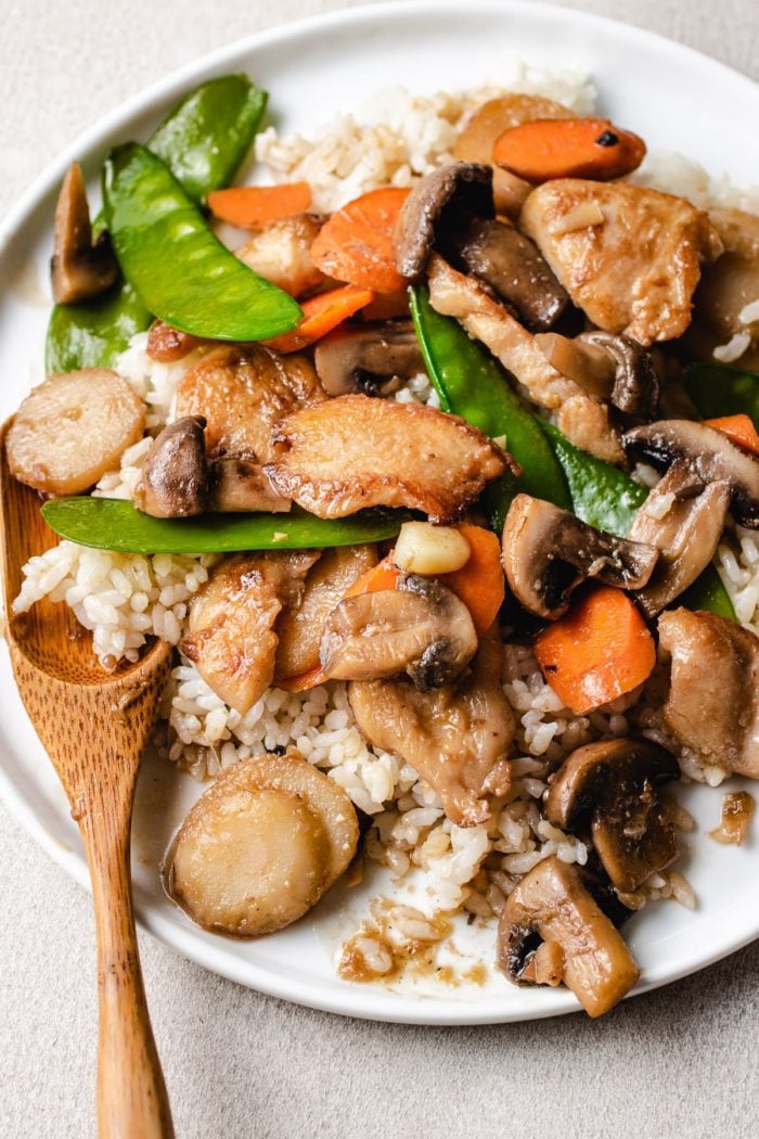 A close shot of the photo shows serving the moo goo gai pan recipe with white rice on a plate with a spoon