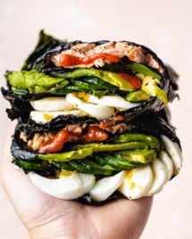 Photo shows one hand holding the stacks of food wrapped in nori sheets