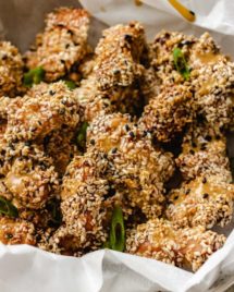 Photo shows baked sesame chicken over a serving bowl