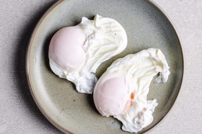 two poached eggs over a light gray dish