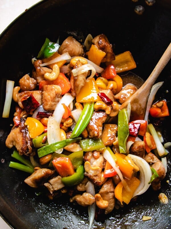 Photo shows stir fried chicken and cashew nuts with sauce in a big wok