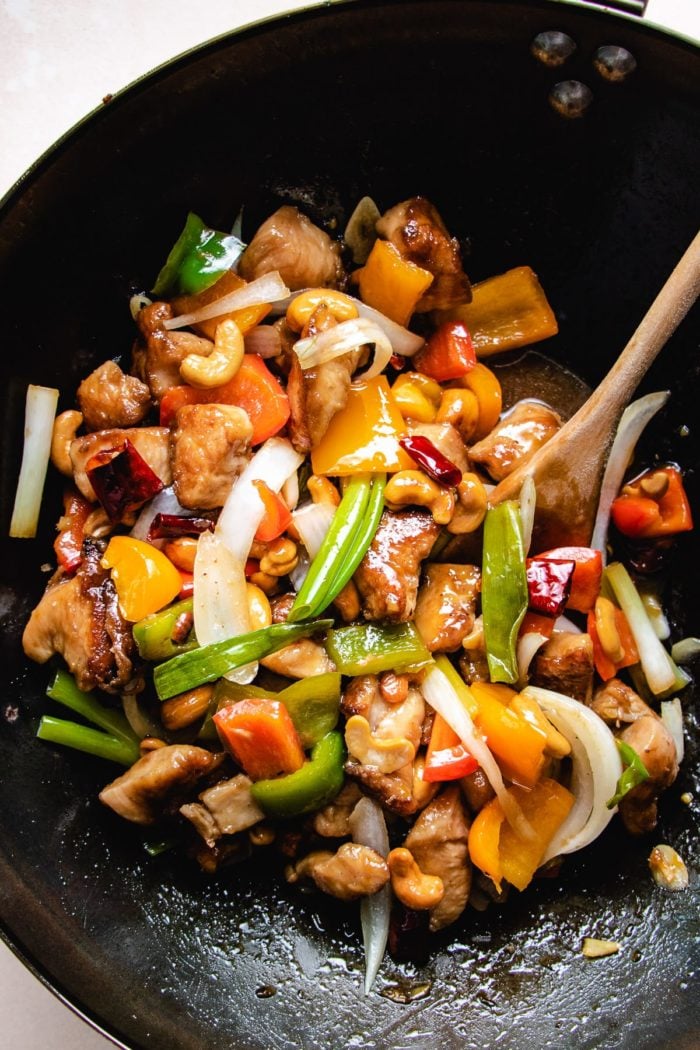 Photo shows stir fried chicken and  nuts and sauce in a big wok