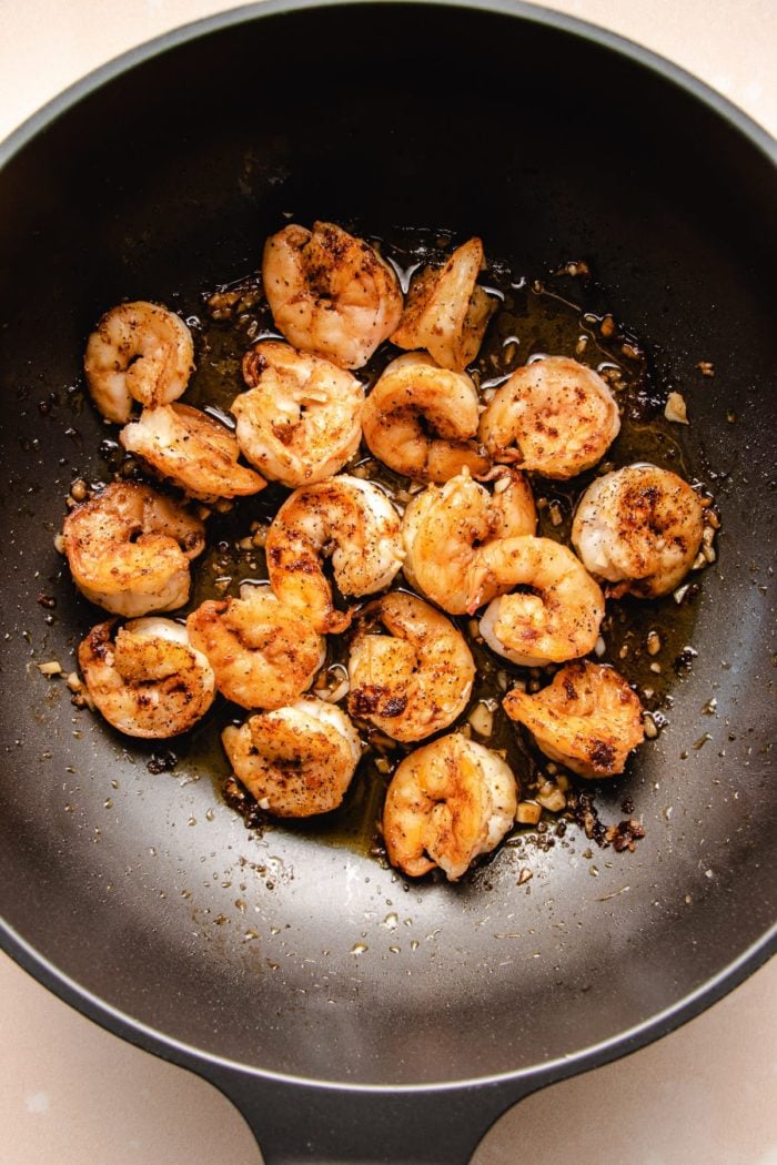 Photo shows large shrimp seasoned and pan fried in a pan
