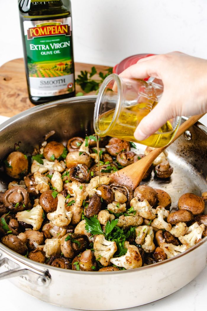 photo shows adding olive to the mushrooms and cauliflower to saute oil to