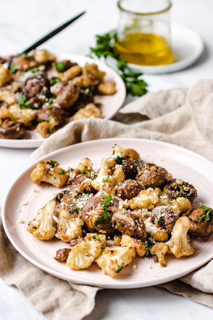 Photo shows garlic mushrooms with cauliflower crumbs served on 2 individual light pink color plates