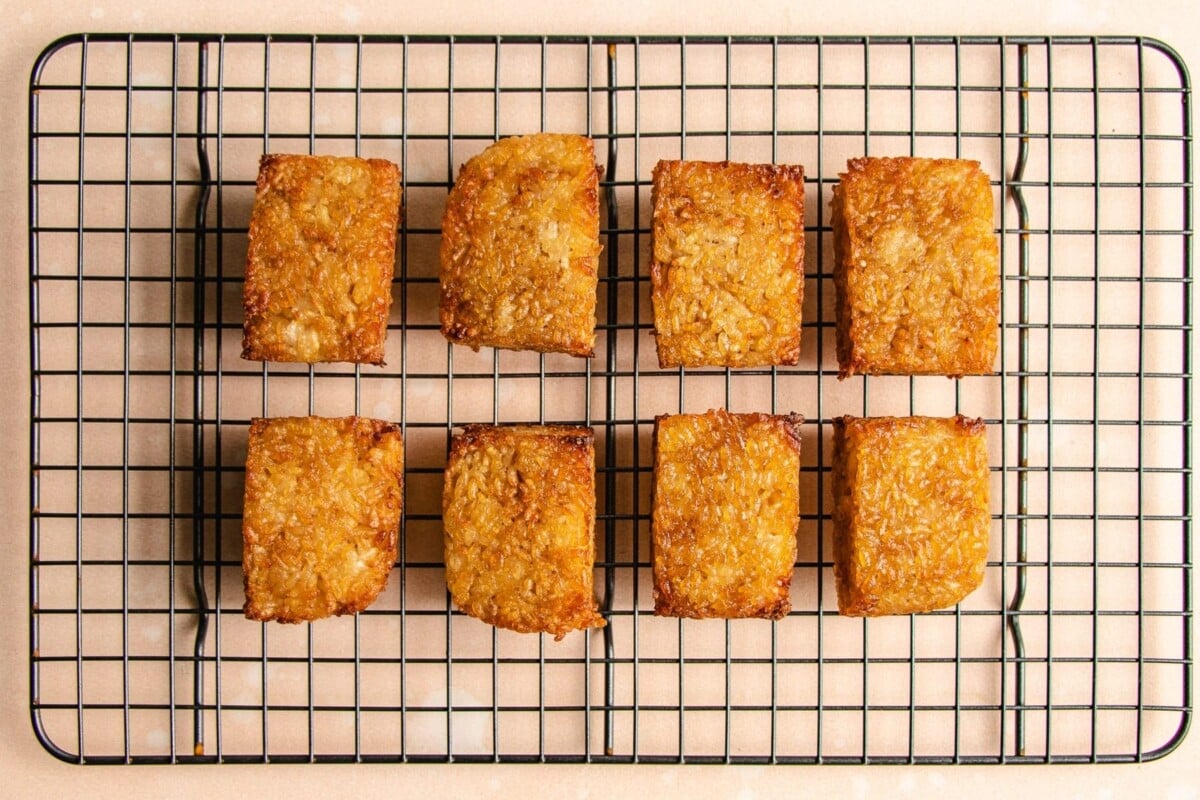 Photo shows resting crispy rice squares over a wire rack to keep them crispy.