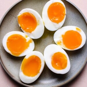 Photo shows soft boiled eggs sliced in half on a gray plate made in air fryer