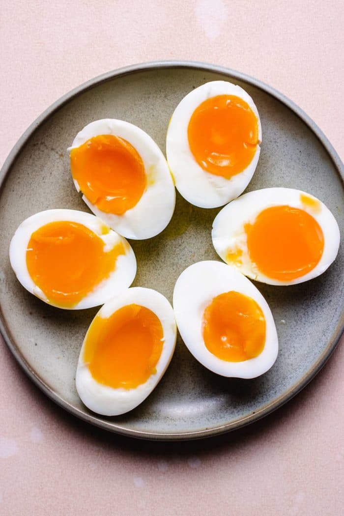 Photo shows soft boiled eggs sliced in half on a gray plate made in air fryer