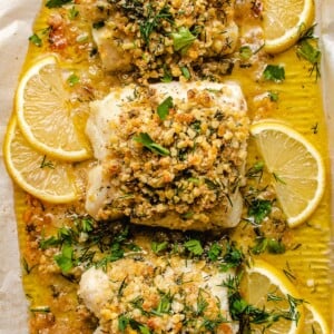 Photo shows 3 cod fillets with panko crust baked in a sheet pan with lemon butter sauce