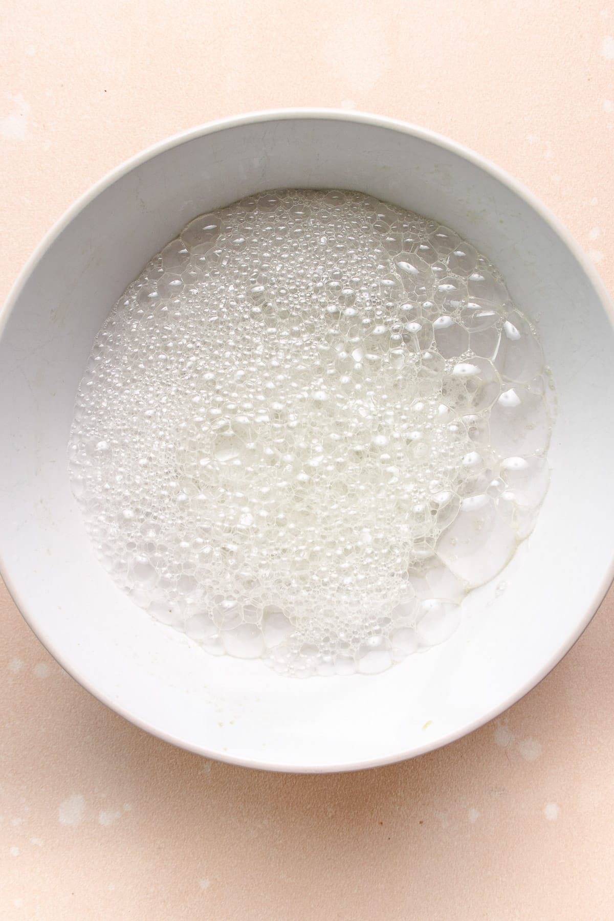 Photo shows a big white bowl with lemon juice mixed with baking soda to create a bubble bath