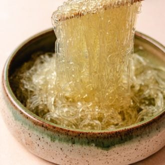 A side close shot shows glass noodles made with kelp that's softened and picking them up with chopsticks