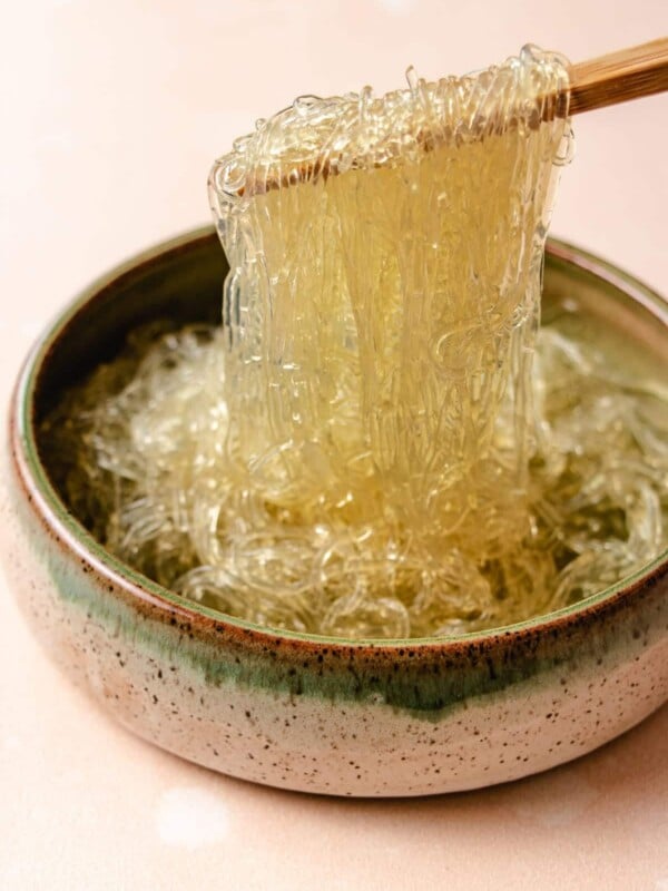 A side close shot shows glass noodles made with kelp that's softened and picking them up with chopsticks