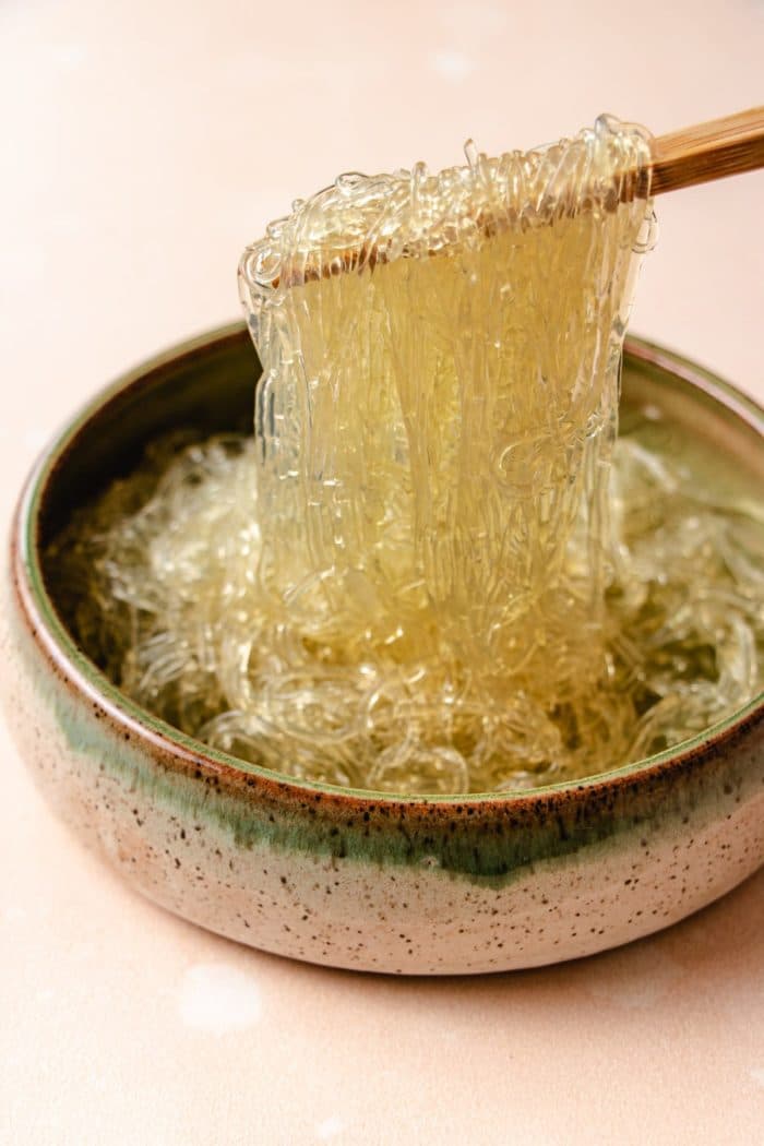 A side close shot shows glass noodles made with kelp that's softened and picking them up with chopsticks