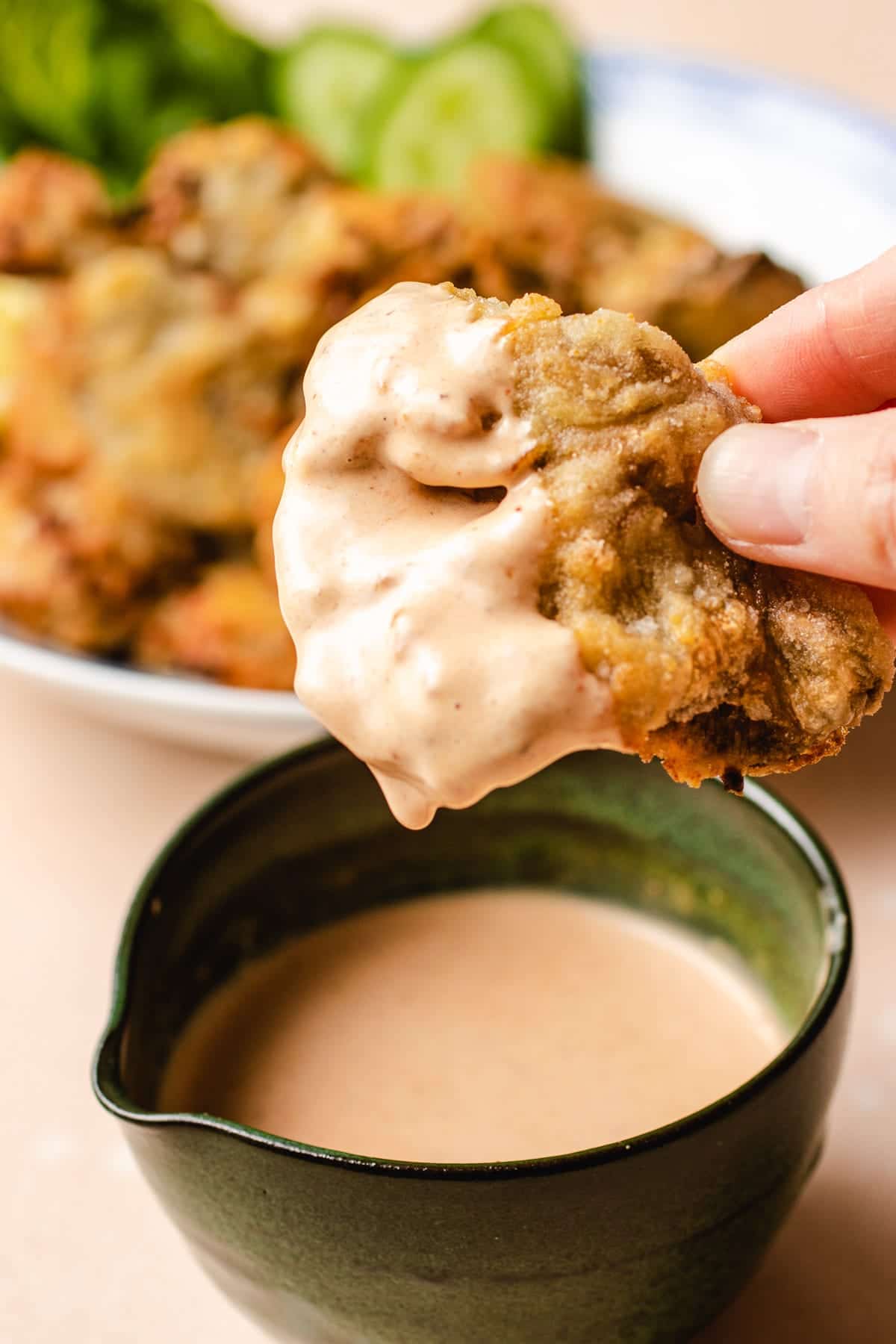 Photo shows dipping the fried oyster mushrooms in the bang bang sauce