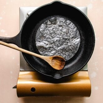 Phot shows grilled rice paper wrapper in a dry and clean cast iron pan on top of a stove