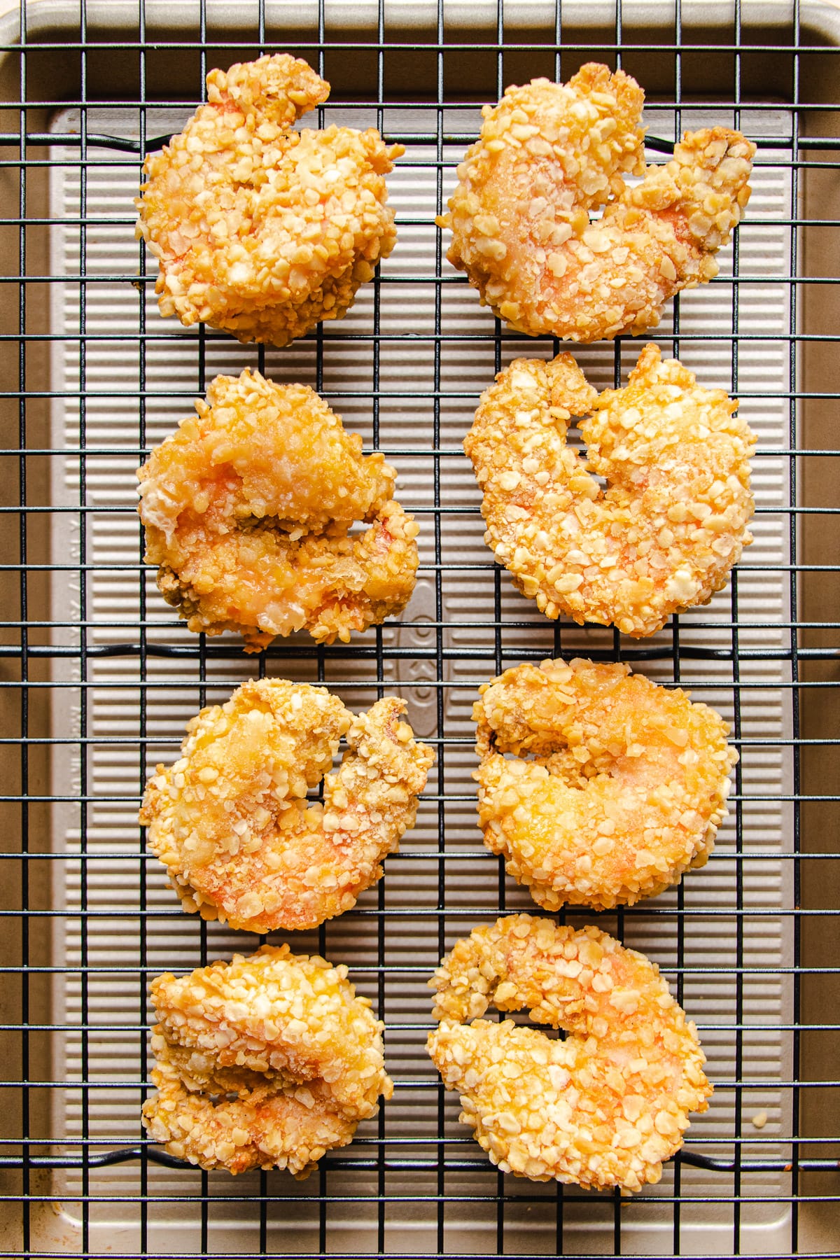 Eight pieces of jumbo air fried shrimp balls rest over a cooling rack before serving