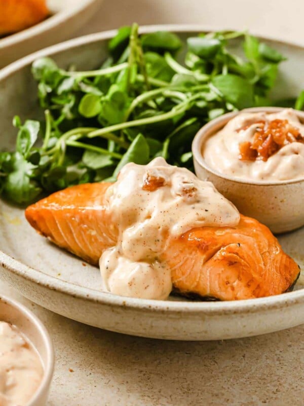 Frozen salmon.air fryer with bacon aioli and salad greens served on a creamed color plate