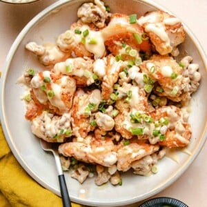 Photo shows a copycat version of panda express honey walnut shrimp served in a white plate with fork on the side