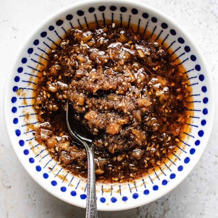 Sha cha sauce recipe shows the sauce after cooked and stored in a bowl with spoon inside