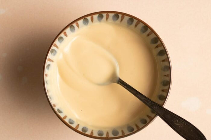 A close shot shows the honey sauce in a bowl with a spoon inside
