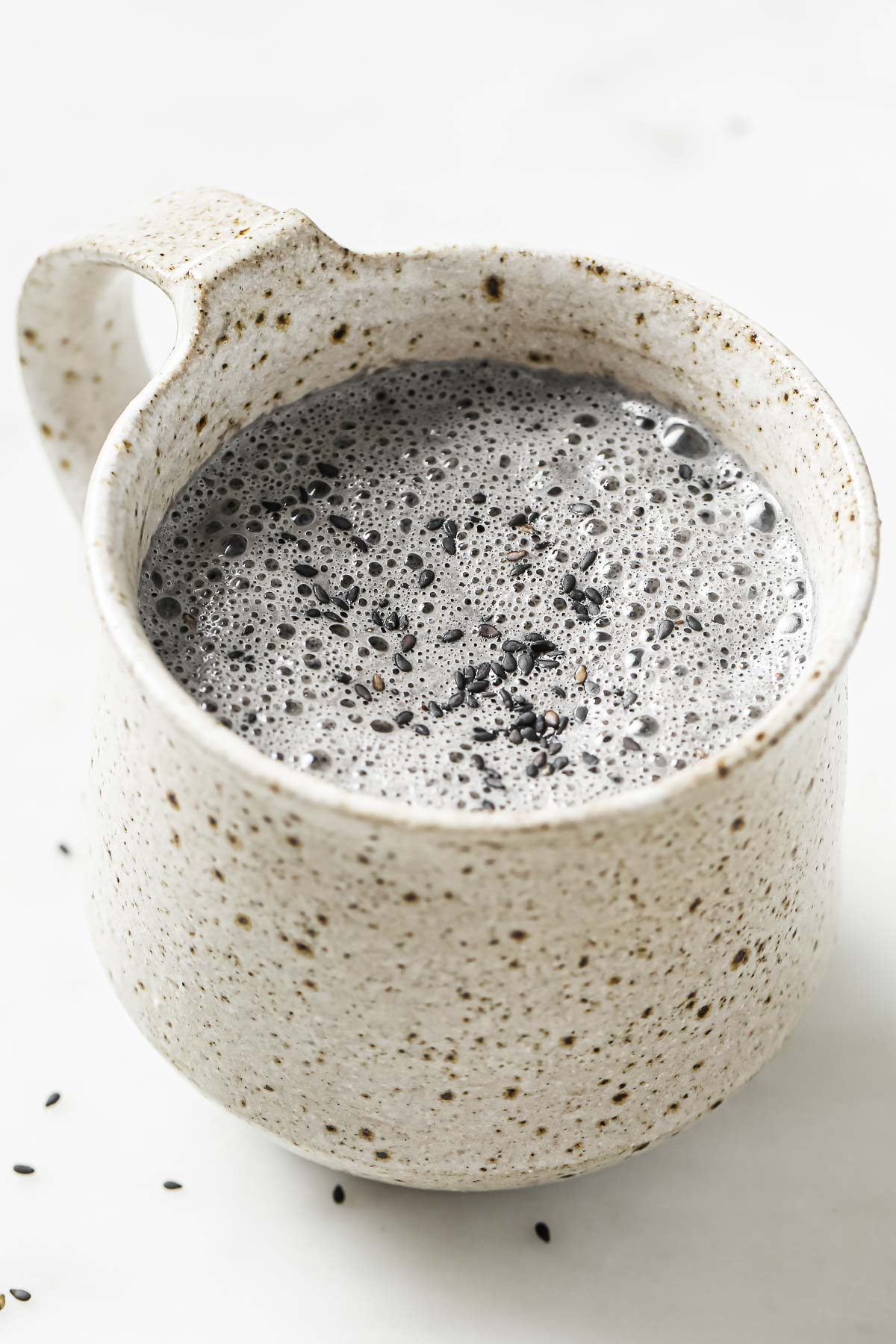 A side close shot shows the sesame latte in a white color mug