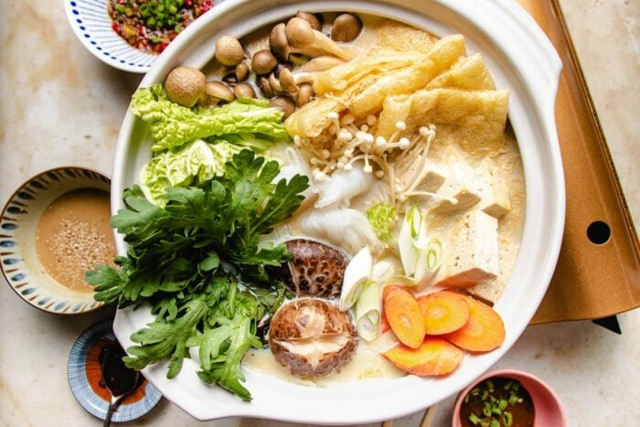 A feature images shows a donabe shabu pot with vegetables cooked inside