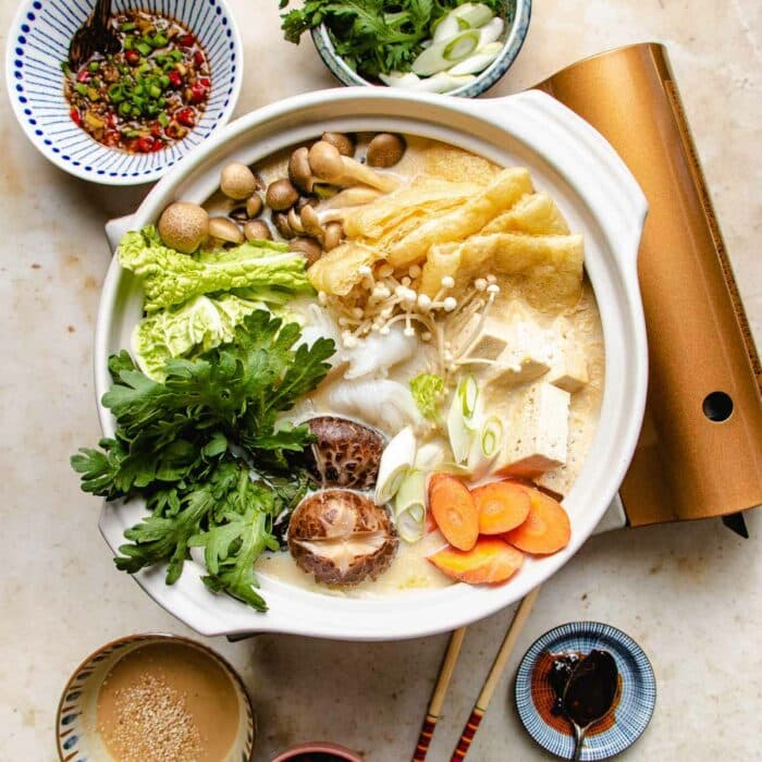 A square shot photo shows the vegan hot pot recipe with dipping sauces on the side