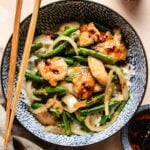 A close shot shows string bean chicken served with rice in a blue color bowl