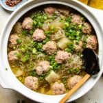 Recipe for winter melon meatball soup served in a white clay soup pot with a soup ladle on the side