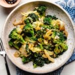 Photo shows copycat super greens recipe with broccoli florets, cabbage, and kale leaves served in a big round shape plate