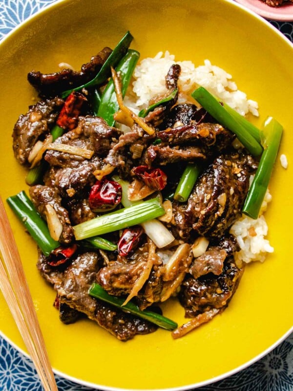 A close shot shows beef stir-fried in shacha sauce and served in a yellow color bowl