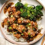 Recipe shows feature image photo with air fry teriyaki chicken served in a white plate with rice and broccoli on the side.