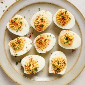 Air fried deviled eggs recipe with creamy filling and garnishes over a large neutral plate