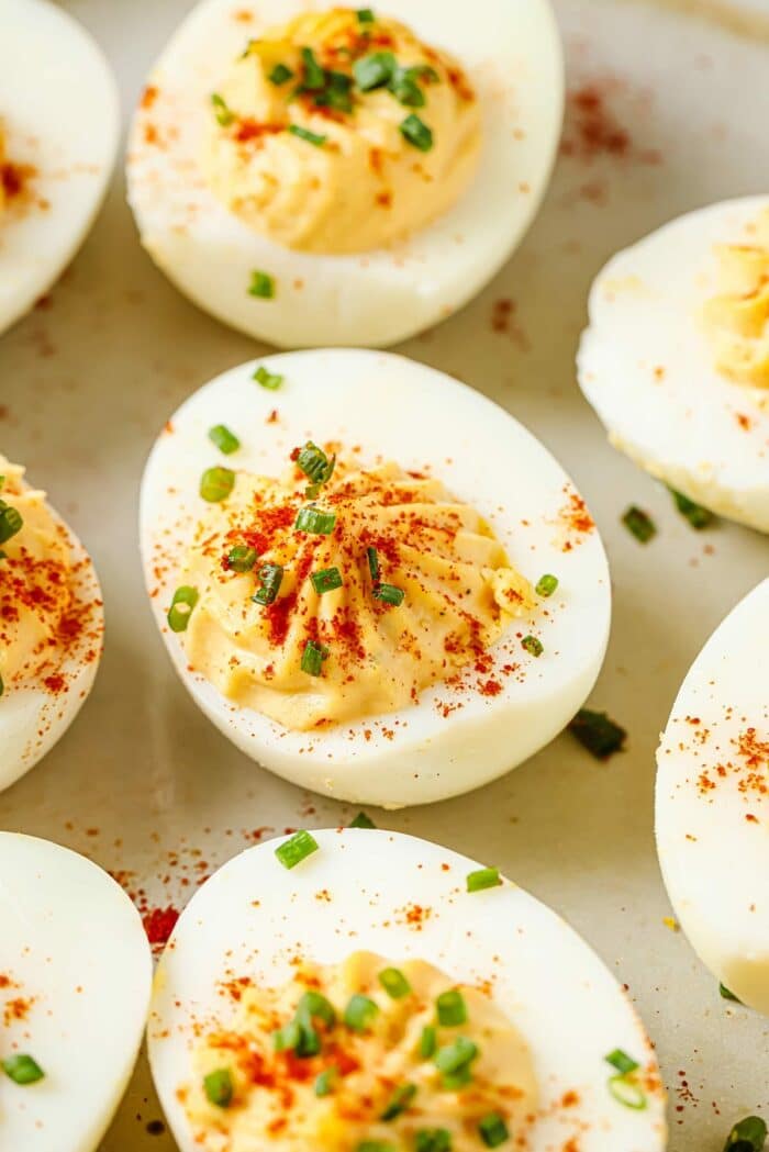 A close shot shows creamy egg yolk filling inside of the egg white over a neutral color plate