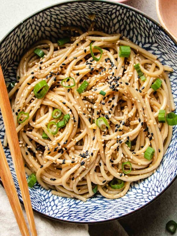 A close shot shows hibachi noodles sitr-fried and served in a blue white color bowl