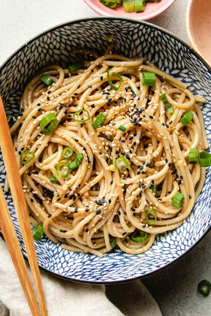 A close shot shows hibachi noodles sitr-fried and served in a blue white color bowl