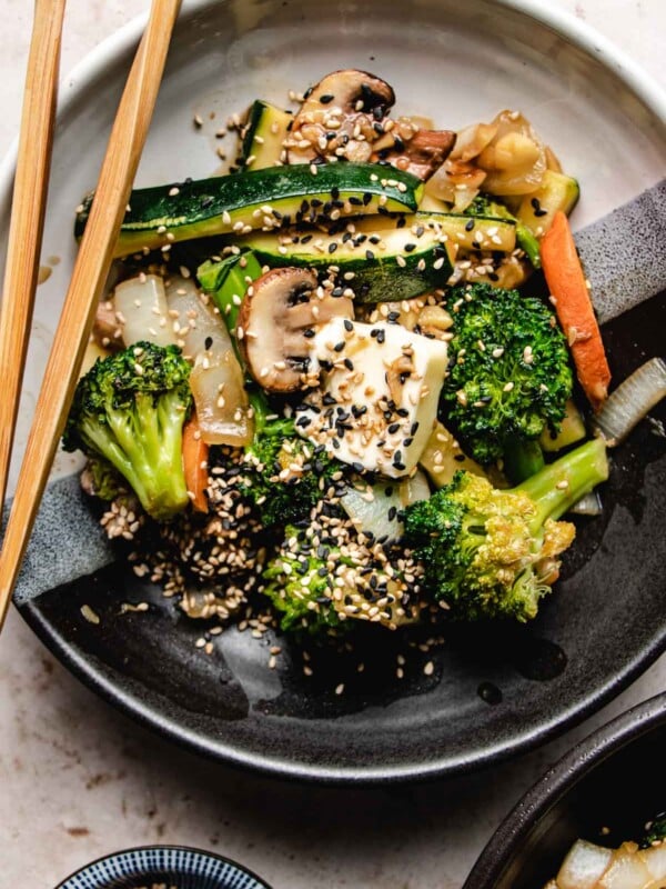 An overhead shot shows hibachi veggies stir-fried and served in a black/white color plate