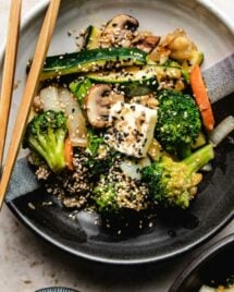 An overhead shot shows hibachi veggies stir-fried and served in a black/white color plate