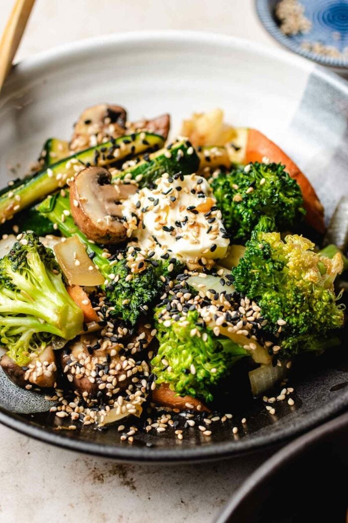 A side close shots shows the finishing vegetables stir-fried and served on a plate