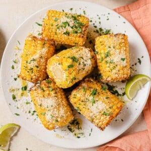 Frozen corn on the cob air fryer recipe served on a white plate with napkins on the side