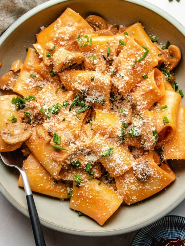 A close overhead shot shows the gochujang pasta noodles covered in sauce and served in a light gray color plate.