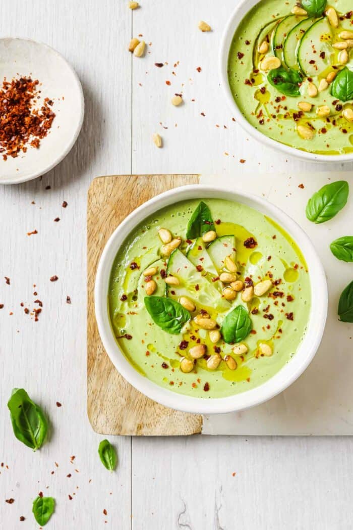 An overhead image shows two bowls of gazpacho without tomatoes served in two white color bowls.