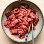 A recipe image shows steak thinly sliced for stir fry use and marinated in a bowl