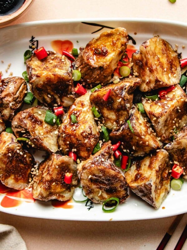 Photo shows Chinese air fried eggplant served on a white plate with sauce on the side