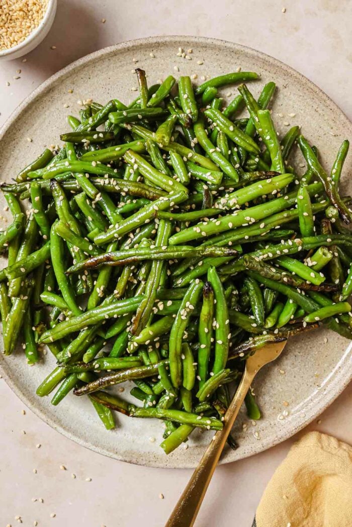Photo shows air fried frozen green beans that are perfectly crisp and tender served on a neutral color plate
