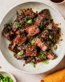 Photo shows thick-cut boneless short ribs cooked in an air fryer with Korean sauce on the side.