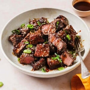 Air fryer short ribs served on a white plate with Korean marinade sauce drizzle on top